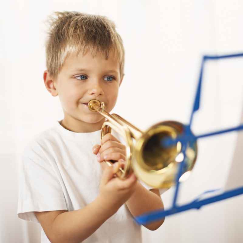 Young boy learning to play trumpet in private trumpet lessons