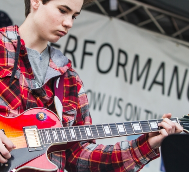 The Lesson Studio student performing at a live event on stage.