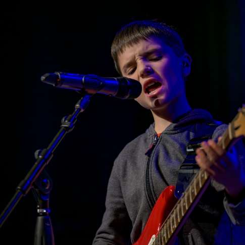 A Lesson Studio student performing on stage an example of Community Spotlight