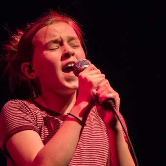 Young teen girl Wrenn Van performing on stage. 