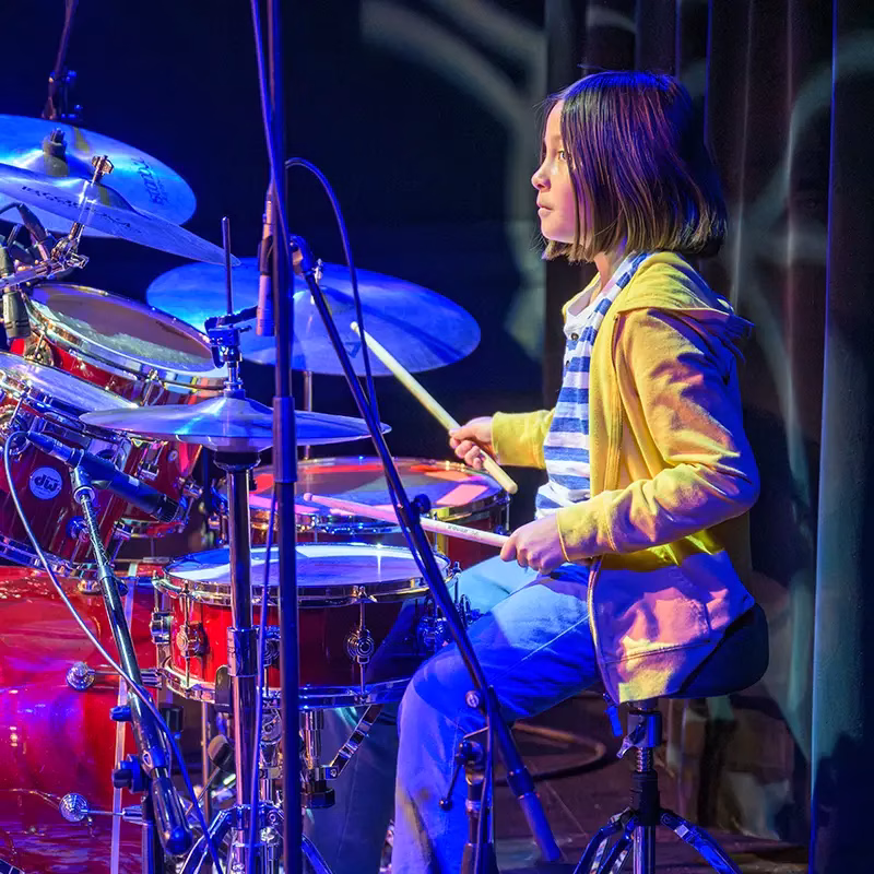 An early age Lesson Studio student playing drums