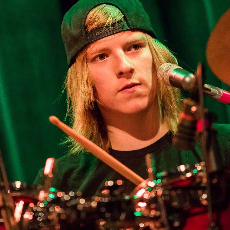 An young adult Lesson Studio student playing drums